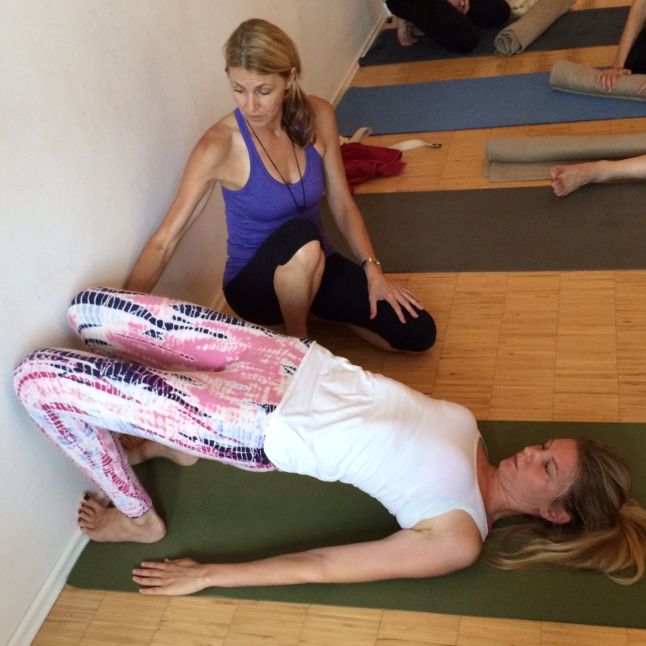 erika helping yoga student in pose